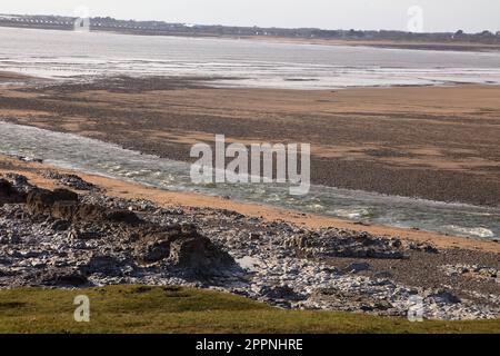 Blick über die Flussmündung auf Ogmore vom Meer über Porthcawl mit der Küste der Gegend. Stockfoto