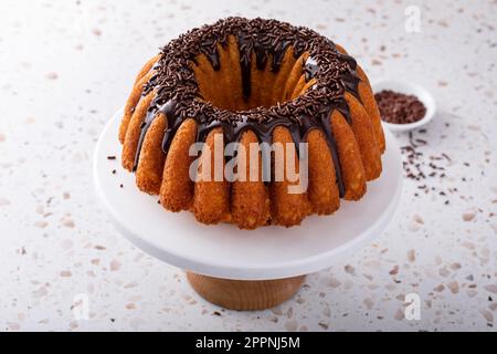 Orangefarbener Pfundkuchen mit dunkler Schokoladenganache und Schokoladenstreuseln Stockfoto