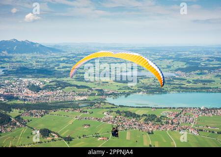 SCHWANGAU - 23. AUGUST: Unbekannter Gleitschirmflieger auf dem Tegelberg in Schwangau am 23. August 2015. Tegelberg ist einer der beliebtesten Stockfoto