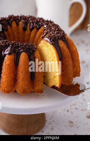 Orangefarbener Pfundkuchen mit dunkler Schokoladenganache und Schokoladenstreuseln Stockfoto