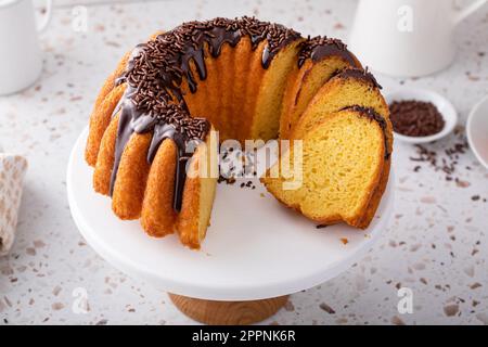 Orangefarbener Pfundkuchen mit dunkler Schokoladenganache und Schokoladenstreuseln Stockfoto