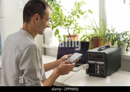 Ein Mann verwendet eine tragbare Ladestation Stockfoto