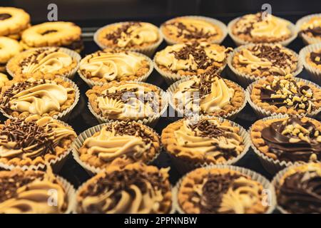 Ein farbenfrohes Foto von verschiedenen Desserts und Gebäck in einem Backwarenfenster. Perfekt für Speisen, Backwaren und Desserts. Stockfoto