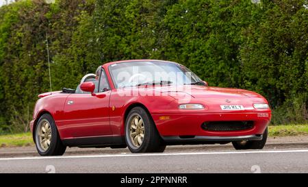 Bicester, Oxon, Großbritannien - April 23. 2023. 1991 roter Mazda MX 5-Oldtimer, der auf einer englischen Landstraße fährt Stockfoto