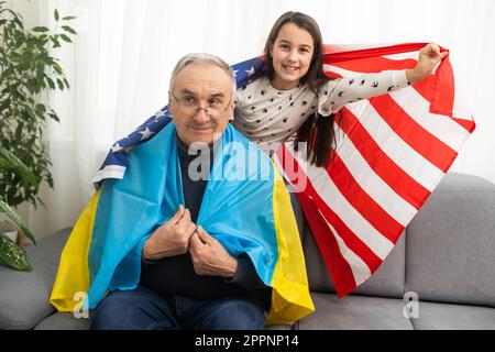 Großvater und Enkelin mit den Flaggen der USA und der Ukraine Stockfoto