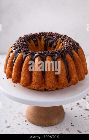 Orangefarbener Pfundkuchen mit dunkler Schokoladenganache und Schokoladenstreuseln Stockfoto