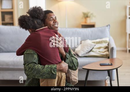 Der afroamerikanische Vater freute sich, sein Kind zu sehen, er umarmte sie und lächelte, während sie im Zimmer standen Stockfoto