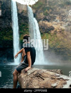Mann steht vor dem Wailua Wasserfall auf Kauai, Hawaii. Hochwertiges Foto. Befindet sich im Wailua River State Park. Hawaii-Reisen Stockfoto