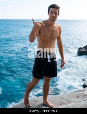 Ein Mann, der von der Spitting Cave auf Oahu, Hawaii, springt. Hochwertiges Foto Stockfoto