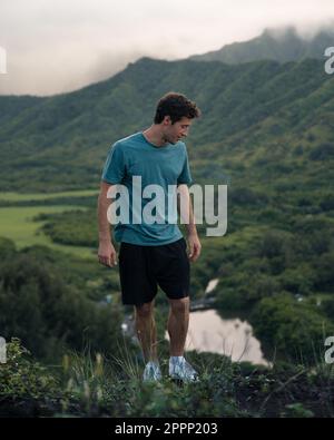 Ein Mann schaut auf die Wanderung zum Crouching Lion auf Oahu, Hawaii. Hochwertiges Foto. Wunderschöne Aussicht auf Oahus Ostküste. Stockfoto