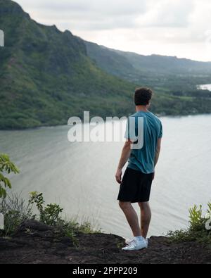 Ein Mann schaut auf die Wanderung zum Crouching Lion auf Oahu, Hawaii. Hochwertiges Foto. Wunderschöne Aussicht auf Oahus Ostküste. Stockfoto