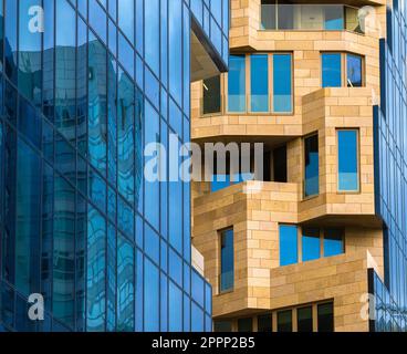 Farbenfrohe Fassaden von Geschäftsgebäuden in Amsterdam, Niederlande, mit vielen Fenstern und der Reflexion eines benachbarten Hochhauses Stockfoto