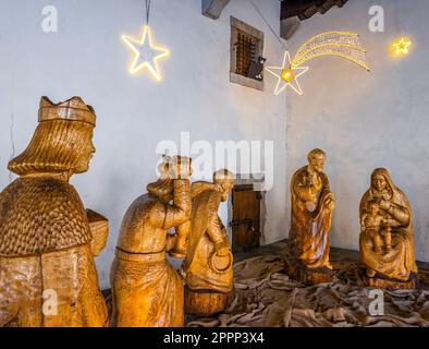 Venzone, Italien - 29. Dezember 2022: Eine lebensgroße Weihnachtsszene aus Holz in einem Rathaus in Venzone, Italien Stockfoto