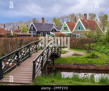 Ein friedliches Wohndorf in Holland, die Zaanse Schans. Antike Gebäude umgeben von Natur und Himmel gesprenkelt von Wolken. Ein Transport von tran Stockfoto