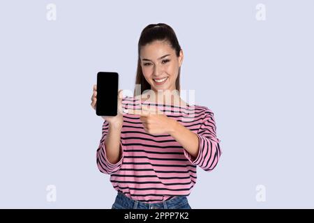 Hübsche junge hispanoamerikanerin mit Smartphone und leerem Bildschirm Stockfoto