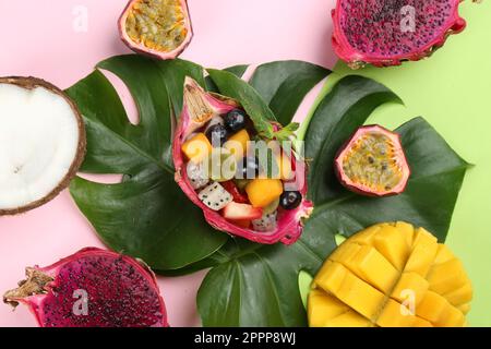 Flach liegend mit köstlichem exotischen Fruchtsalat auf farbigem Hintergrund Stockfoto
