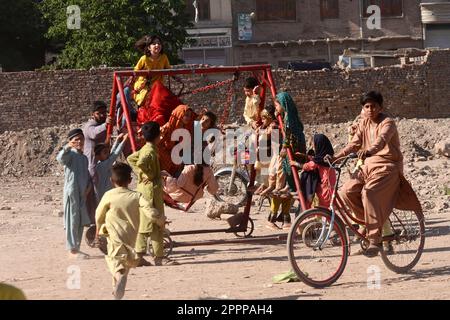 Peshawar, Khyber Pakhtunkhwa, Pakistan. 23. April 2023. Kinder genießen Schaukeln während der Eid al-Fitr Feiern in Peshawar. Moslems auf der ganzen Welt feiern Eid al-Fitr, das dreitägige Festival, das das Ende des heiligen muslimischen Fastenmonats Ramadan markiert. Eid al-Fitr ist einer der beiden großen Feiertage im Islam. (Kreditbild: © Hussain Ali/Pacific Press via ZUMA Press Wire) NUR REDAKTIONELLE VERWENDUNG! Nicht für den kommerziellen GEBRAUCH! Stockfoto