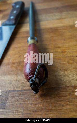 Metzgerstahl und Messer Vintage auf einem Holztisch, Arbeitsfläche Stockfoto