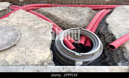 Installation eines Abwasserrohrs aus Kunststoff während der Bauphase. Strassenumbaustelle mit Abwasserrohren aus Kunststoff. Baustelle mit e Stockfoto