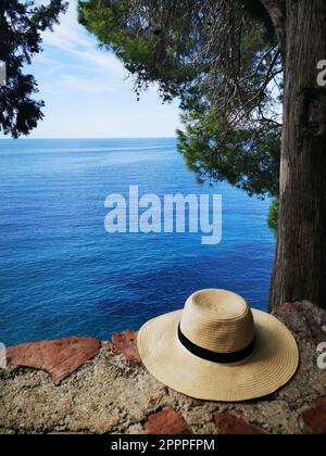 Ein Strohhut auf einer Steinmauer am Meer in Montenegro Stockfoto