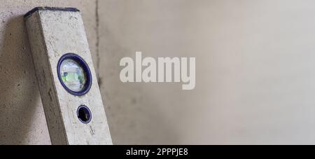 Abgenutzte Libelle aus Aluminium, an der Wand auf der Baustelle platziert, leerer Platz für Text rechts Stockfoto