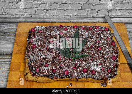 Marihuana-Kuchen mit trockenen roten Johannisbeeren und Schokolade auf arabischer Farbplatte Stockfoto