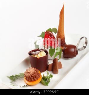Italienische Speisenrezepte, Gianduia Schokolade Dessert mit gefülltem Pfirsich, Vanille Mousse, Eis. Stockfoto