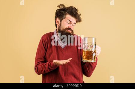 oktoberfest-Festival. Betrunkener Mann mit Craft-Bier-Becher. Mann, der Bier vom Fass in der Bar oder im Pub trinkt. Bärtiger Mann mit einem Glas köstlichem Bier Stockfoto