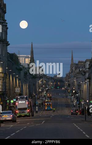 The Setting Full Moon (Pink Moon) über dem westlichen Ende der Union Street im Stadtzentrum von Aberdeen früh am Morgen vor der Daybreak Stockfoto