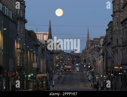 Blick auf die Union Street im Stadtzentrum von Aberdeen vor der Morgendämmerung mit Vollmond (April's Pink Moon), gelegen zwischen zwei Kirchenspitzen am West End Stockfoto