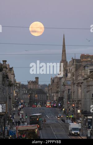 Ein Blick entlang der Union Street, der Hauptdurchgangsstraße im Stadtzentrum von Aberdeen, vor Sonnenaufgang mit Vollmond-Kulisse am West End Anfang April Stockfoto