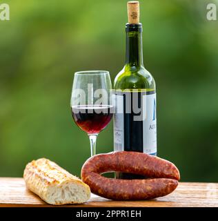 Rotwein in einem Glas mit Brot und Salami Stockfoto