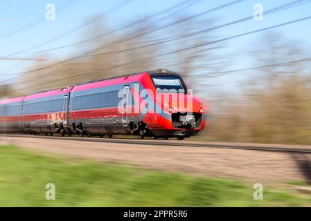 Hochgeschwindigkeitszug in Bewegung auf dem Land an einem sonnigen Tag. Bewegungsunschärfe-Effekt. Stockfoto
