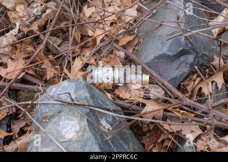 Everett, Massachusetts, USA-5. April 2023: Leere Flasche mit Spirituosen auf dem Boden. Die örtlichen Gemeinden erwägen ein Verbot des Verkaufs von Einwegalkoholflaschen. Stockfoto