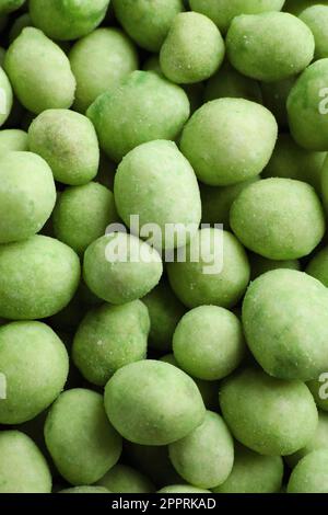 Leckere Wasabi-beschichtete Erdnüsse als Hintergrund, Draufsicht Stockfoto