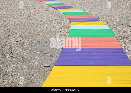 Farbenfroher Holzsteg am Kieselstrand. Platz für Text Stockfoto