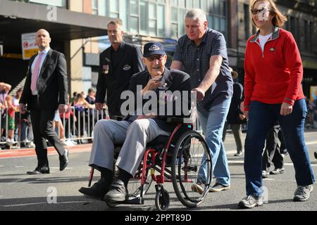 Sydney, Australien. 25. April 2023. Ein Veteran im Rollstuhl wird während eines märz während der ANZAC Day Parade am 25. April 2023 in Sydney, Australien, begleitet. Der Anzac Day ist ein landesweiter Feiertag in Australien, der traditionell von einem Morgengottesdienst während der ursprünglichen Landung in Gallipoli geprägt ist und den ganzen Tag über mit Zeremonien und Paraden geehrt wird. Der Anzac-Tag erinnert an den Tag, an dem das australische und neuseeländische Armeekorps (ANZAC) am 25. April 1915 während des Ersten Weltkriegs an den Küsten von Gallipoli gelandet ist (Foto: Izhar Khan) Kredit: Izhar Ahmed Khan/Alamy Live News/Alamy Live New Stockfoto