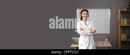 Porträt eines jungen Lehrers, der ein schnurloses Headset in der Nähe des Whiteboards im Klassenzimmer trägt. Chemieunterricht im Internet. Stockfoto
