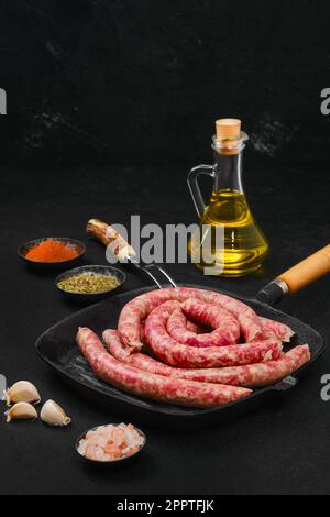 Dünne würzige Rindfleischwürste auf einer Gusseisenpfanne Stockfoto