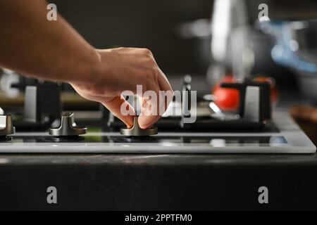 Handgas am Ofen einschalten, piezoelektrische Zündung benutzen Stockfoto