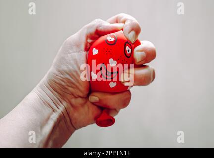 Nahaufnahme einer Frau, die mit der Hand einen selbstgemachten Stressball aus Mehl und Ballon drückt. Stockfoto