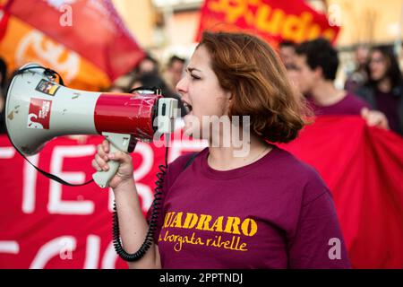 Eine junge Frau, die das T-Shirt mit der Aufschrift „Quadraro borgata ribelle“ (Quadraro rebellische Gemeinde) trägt, ruft während der Demonstration Slogans auf einem Megafon. Demonstration auf den Straßen des Viertels Quadraro von Rom, organisiert von der ANPI (Nationale Vereinigung der italienischen Partisanen) und der VII. Gemeinde Rom zur Erinnerung an die Zusammenführung des Quadraro. Die Verhaftung der Quadraro war eine Nazi-faschistische Militäroperation vom 17. April 1944, bei der etwa zweitausend Menschen verhaftet wurden, von denen 683 in deutsche Konzentrationslager deportiert wurden. (Foto von Marcello Stockfoto