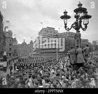 Aktenfoto vom 02.06/53, von Menschenmassen im Regen am Trafalgar Square, London, die beobachten, wie die Truppen nach der Krönung von Königin Elizabeth II. An der Rückkehr von Westminster Abbey vorbeimarschieren Die Krönung von 1953 war in den harten Nachkriegsjahren, in denen Millionen den historischen Tag feierten, ein Motivationsschub. Elizabeth II. Wurde am 2 1953. Juni in einer zutiefst religiösen Zeremonie in Westminster Abbey gekrönt. Ausgabedatum: Dienstag, 25. April 2023. Stockfoto