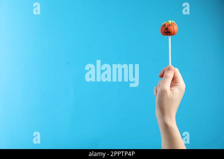 Frau mit köstlichem Kürbiskuchen und Platz für Text auf hellblauem Hintergrund, Nahaufnahme. Halloween-Feier Stockfoto