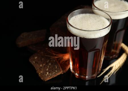 Köstlicher Kavass, Brot und Stacheln auf schwarzem Hintergrund Stockfoto