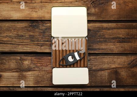 Humidor mit kubanischen Zigarren und Schneidemaschine auf Holztisch, Draufsicht Stockfoto