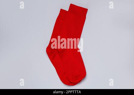 Ein Paar rote Socken auf hellgrauem Hintergrund, flach liegend Stockfoto
