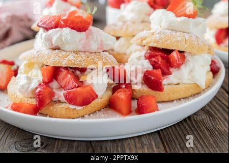 Erdbeerkuchen mit Schlagsahne. Traditionelle Shortcakes mit marinierten Erdbeeren. Stockfoto