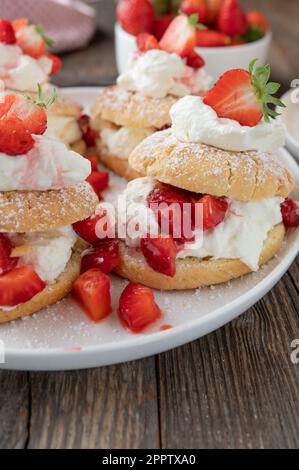 Sommer-Erdbeerkuchen oder Gebäck mit traditionellen Shortcakes gefüllt mit Schlagsahne und marinierten Erdbeeren Stockfoto