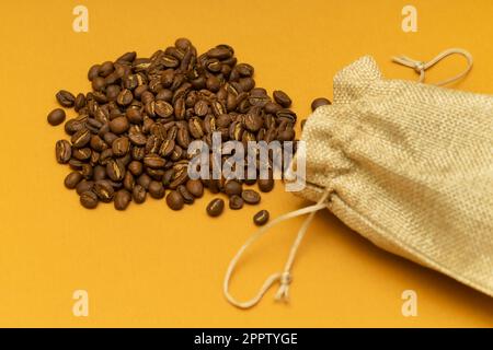 Kaffeebohnen sind aus der Tüte geschüttet. Kaffeebohnen in einer Tüte. Natürliche Kaffeebohne Stockfoto